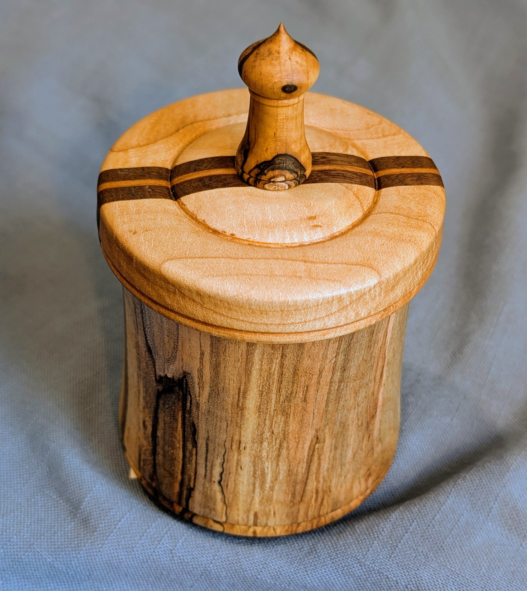 Spalted cherry box with a domed maple lid, walnut stripes, and a turned spalted finial