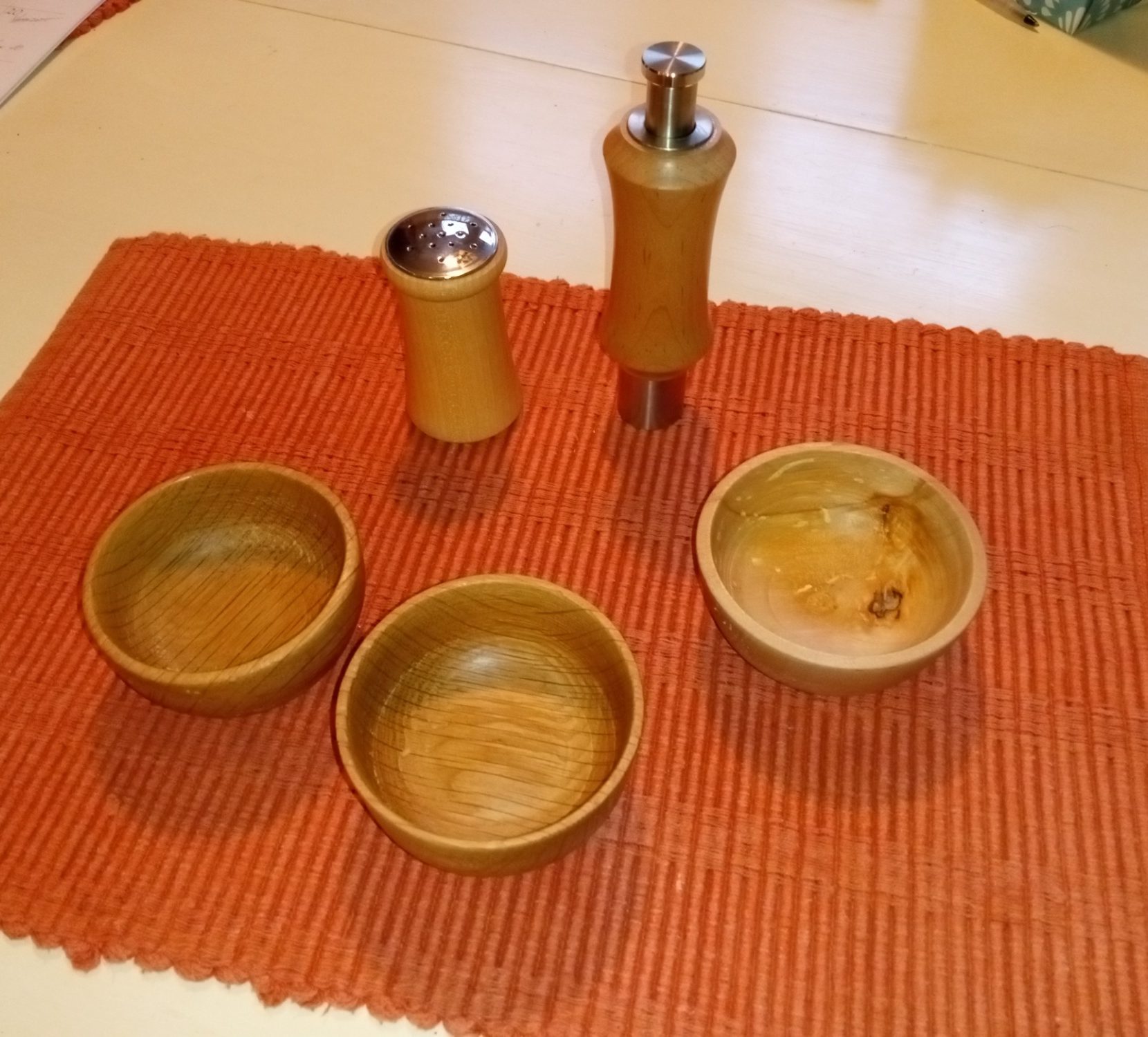 One hand pepper mill, salt shaker, and condiment bowls